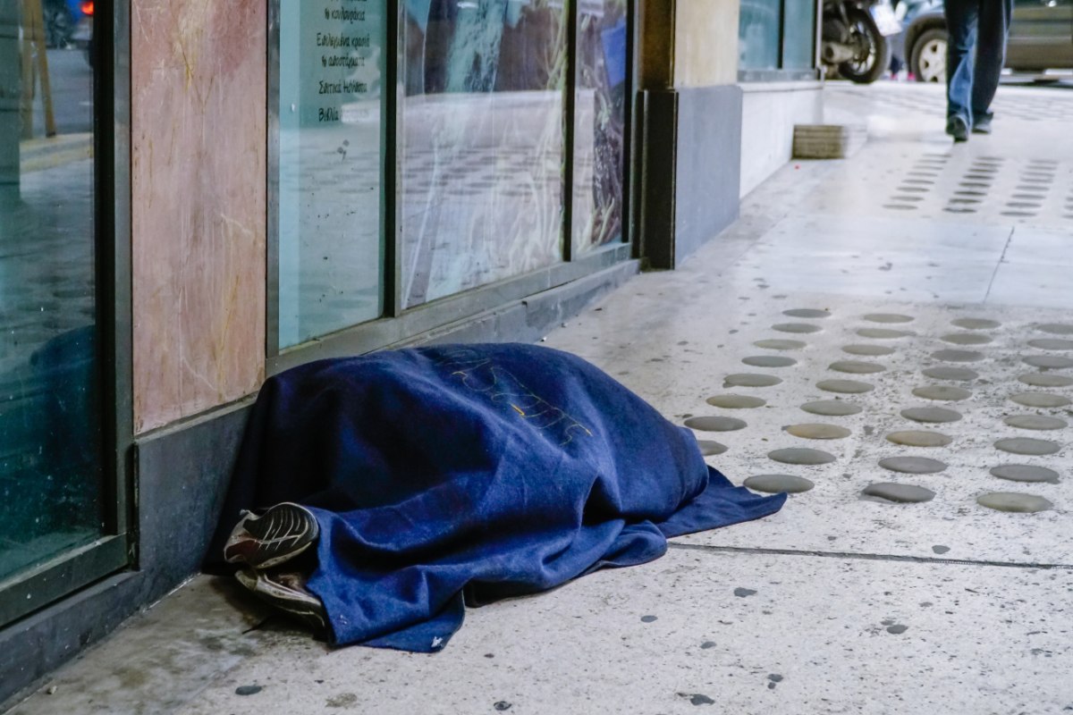 Στέγαση: «Αλλαγή μοντέλου» - Έκθεση 75 σημείων για το σχέδιο της Κομισιόν που αναμένεται εντός Δεκεμβρίου 2 εικόνα που δείχνει άστεγο να κοιμάται στον δρόμο, σκεπασμένος με μια λεπτή κουβέρτα