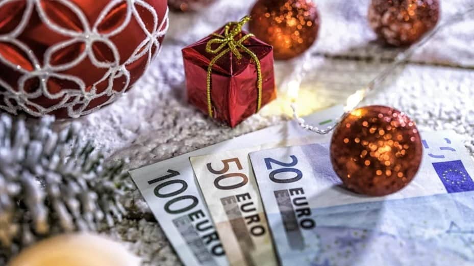 Χαρτονομίσματα απλωμένα σε χριστουγεννιάτικα στολίδια