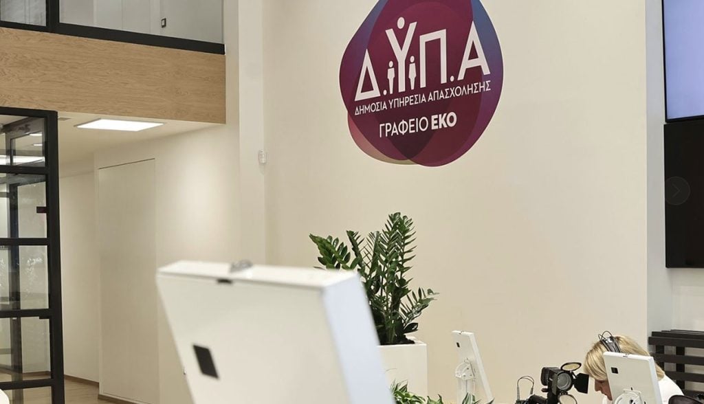 'Ολα όσα πρέπει να γνωρίζετε για το voucher των 750 ευρώ 1 Εσωτερικός χώρος με κρεμ χρώματα στους τοίχους και λογότυπο της ΔΥΠΑ. Μία ξανθιά κυρία, υπάλληλος, με ακουστικά μπροστά σε έναν λευκό υπολογιστή. ΔΥΠΑ - Εκπαιδευτικοί: Αναρτήθηκαν οι πίνακες για 70 μόνιμες θέσεις